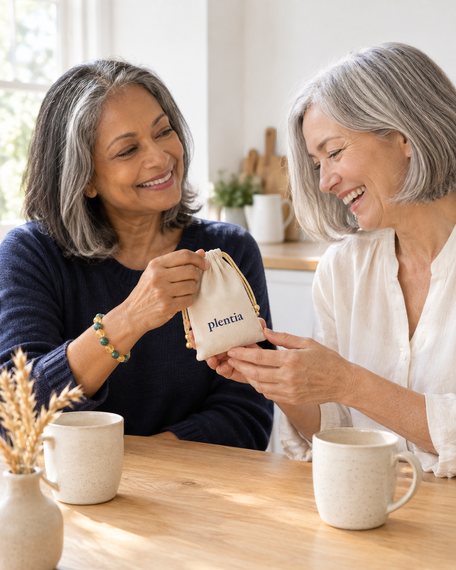 Two friends sharing a Plentia bracelet pouch at the kitchen table